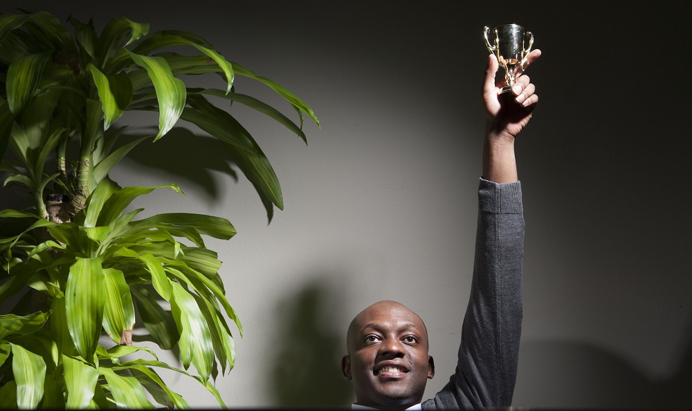 Businessman holding trophy in office